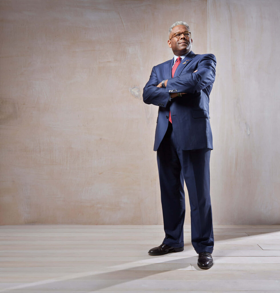 Retired Lt Col Allen West in formal suit standing confidently with minimalist background wallpaper