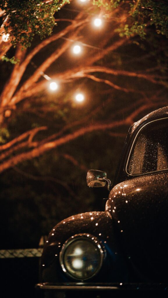 Retro Black Car in Rainy Night: Nostalgic Moody Wallpaper