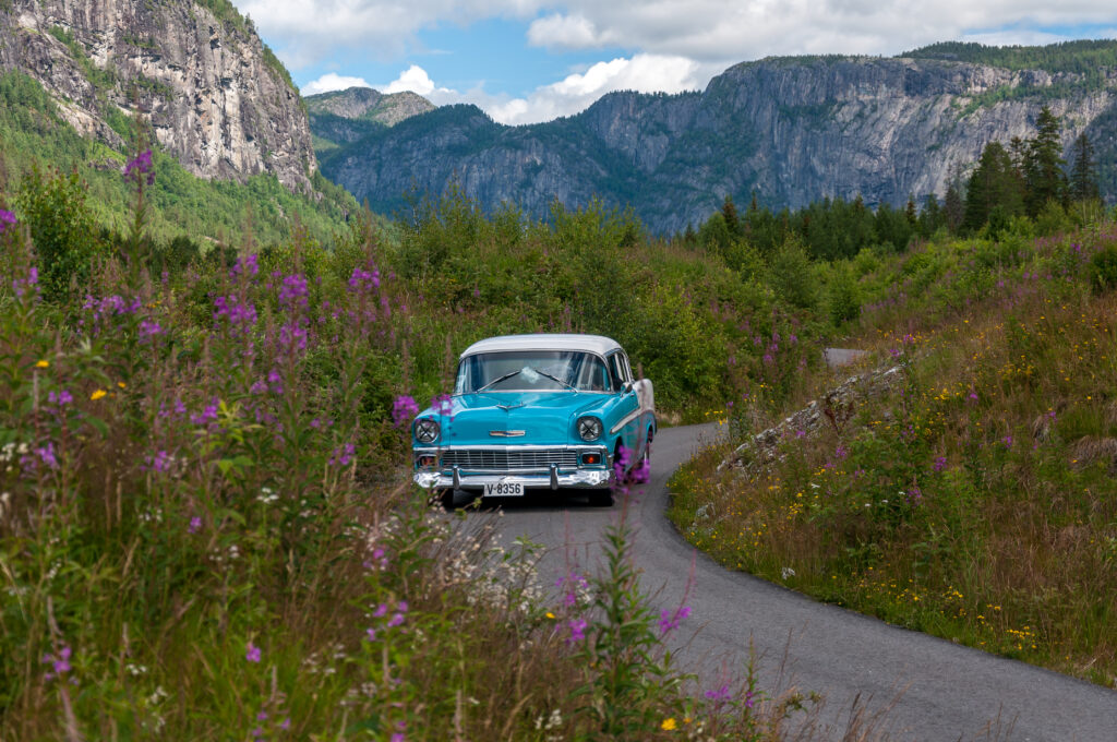 Retro Blue Car on Scenic Winding Road - Nostalgic Landscape Wallpaper