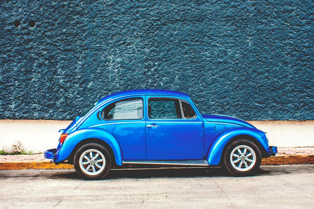 Retro Blue Car Wallpaper Against Dark Textured Wall
