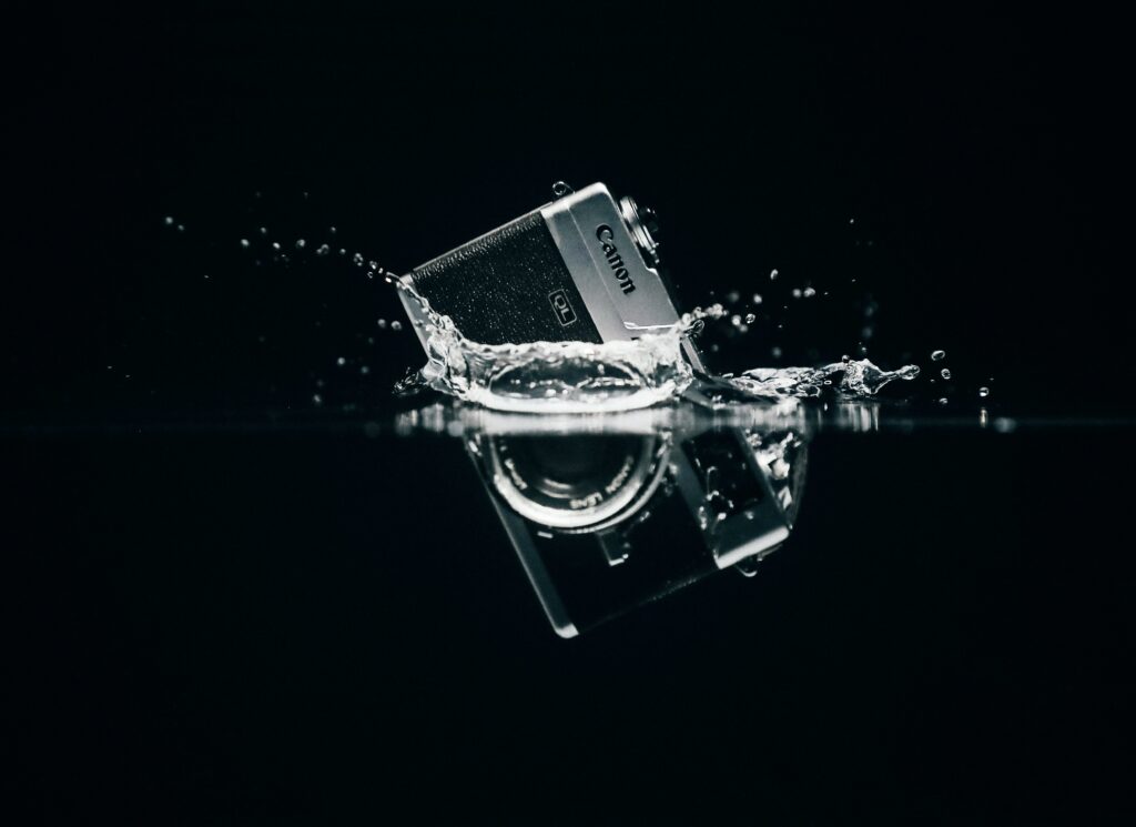Retro Camera Wallpaper: Sleek Design in Water with Dark Background