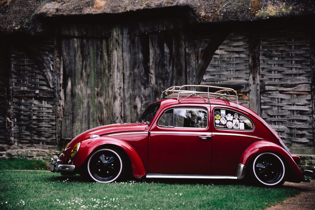 Retro Red Car Wallpaper: Classic Style Against Rustic Background