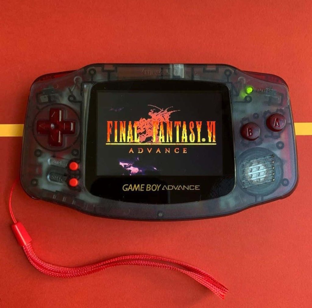 Transparent Game Boy Advance with Final Fantasy VI screen on vibrant red background wallpaper