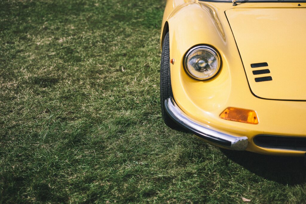 Retro Yellow Car Close-Up on Grass: Classic Automotive Design Wallpaper