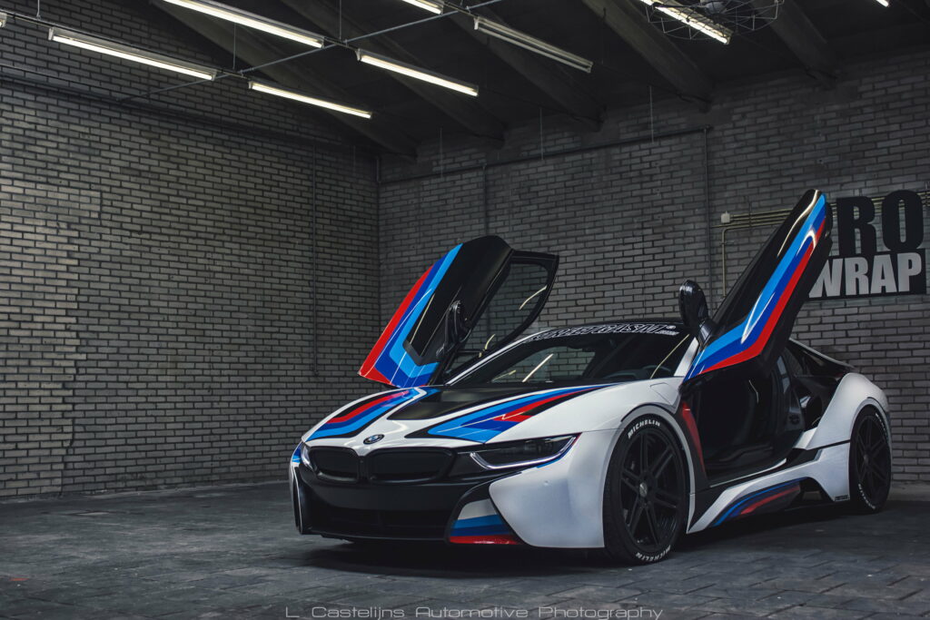 Customized BMW i8 hybrid supercar with butterfly doors in red white and blue livery in garage Wallpaper