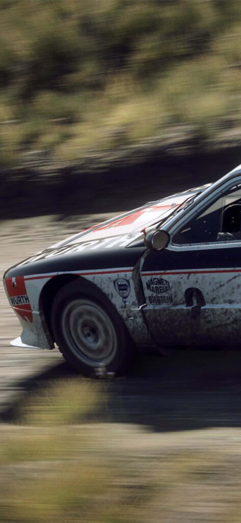 High-Speed Rally Car Covered in Dirt Racing Through Rally Stage - Action Packed Wallpaper
