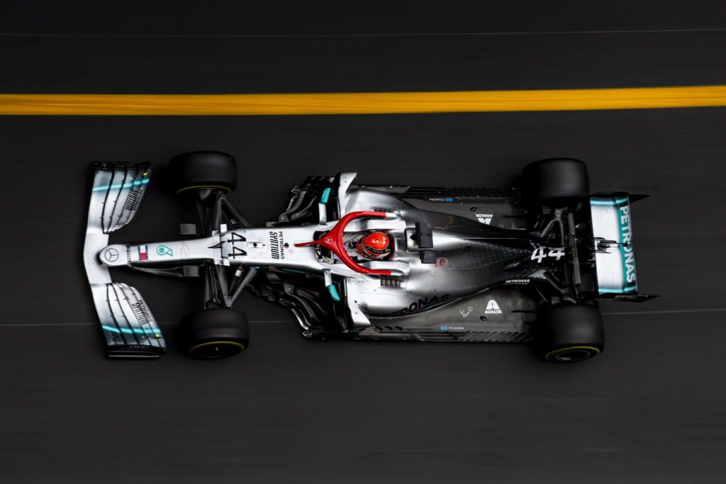 Champion's Ride: A Stunning Wallpaper Background Photo of Lewis Hamilton and Mercedes AMG Petronas in Formula 1 Action
