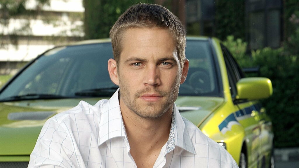 Speed Demon: Paul Walker Captivated Behind the Wheel of a Vibrant Yellow Car in this Striking QHD Wallpaper