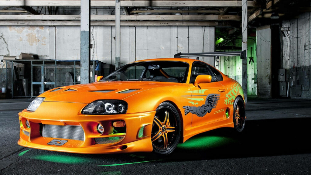 Metallic Majesty: A stunning Toyota Supra in Orange and Green Wallpaper