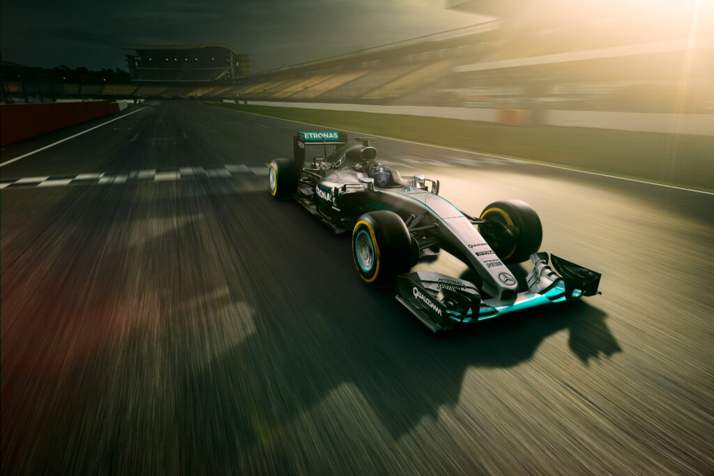 Mercedes AMG Petronas F1 car speeding on sunlit track with dynamic motion blur 4K wallpaper