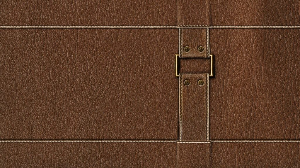 Brown leather wallpaper with textured stitching and metallic buckle clasp for elegant screens