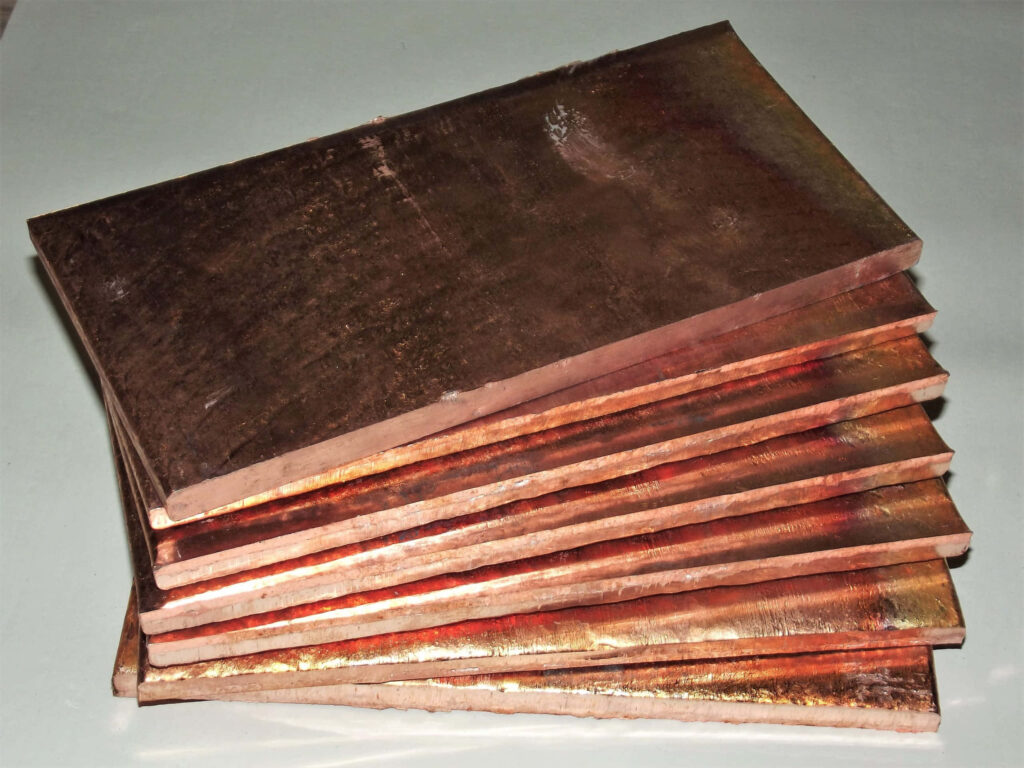 Close-up of stacked copper sheets wallpaper showing rich metallic sheen and warm earthy tones