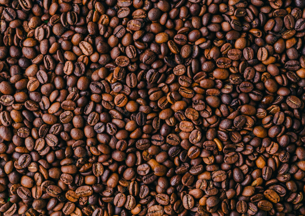 Closeup of roasted coffee beans texture rich dark brown color wallpaper background