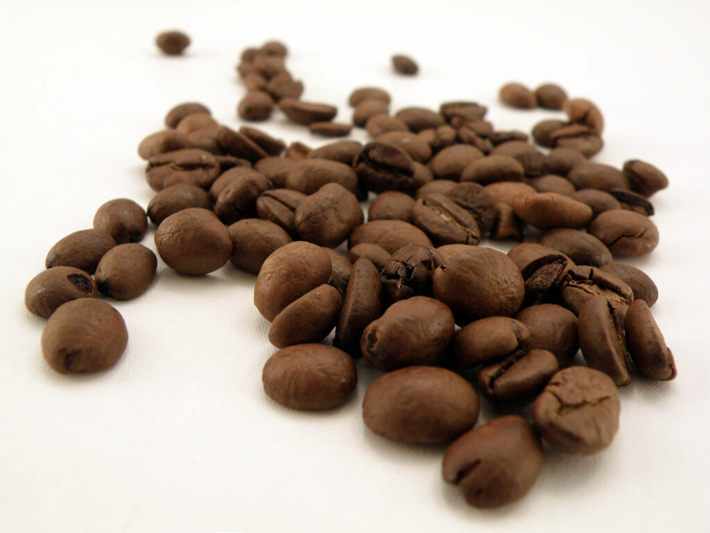 Textured Coffee Beans on White Background | Earthy Wallpaper Image