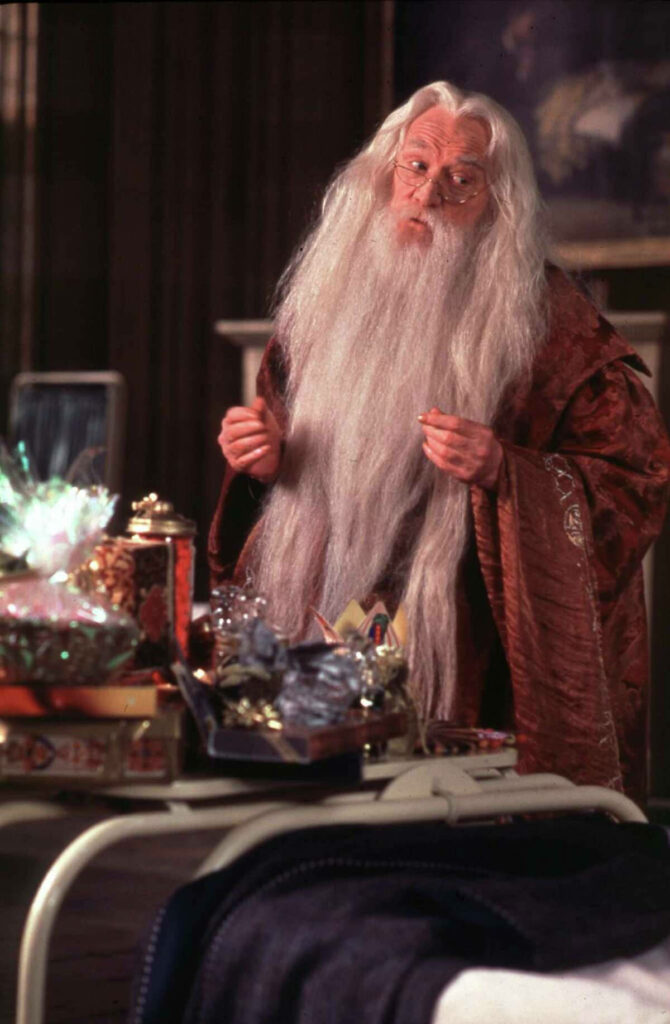 Richard Harris as Albus Dumbledore with magical items on table Harry Potter scene wallpaper background