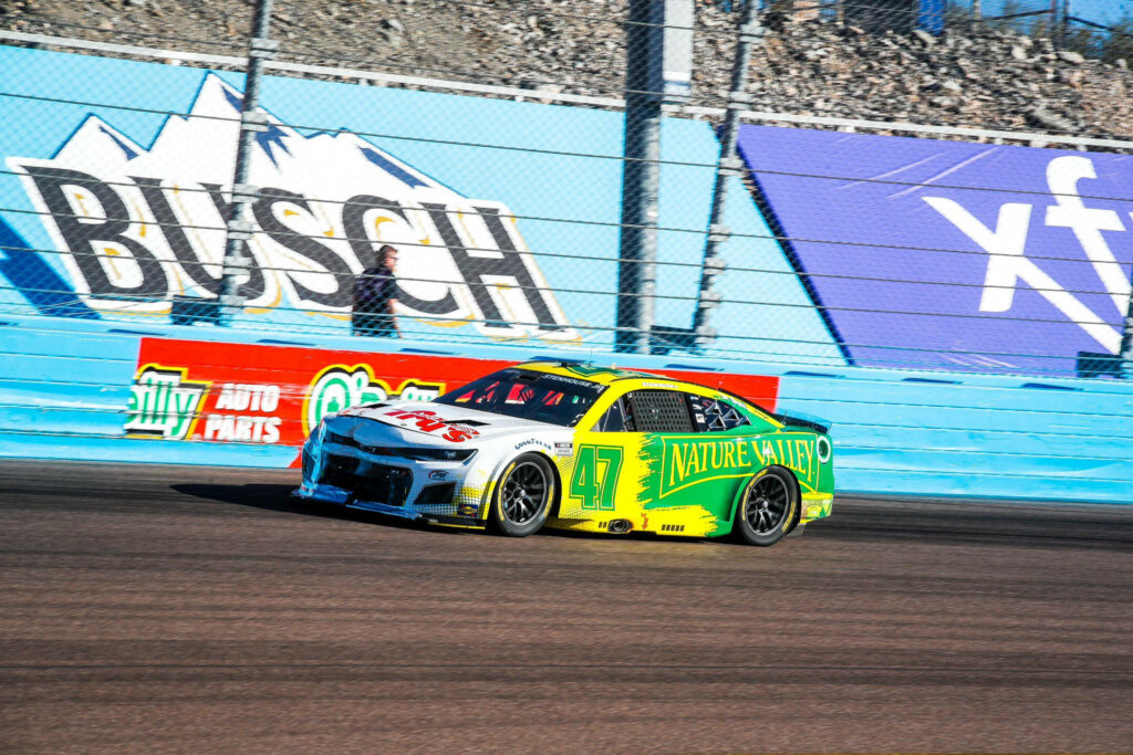 Ricky Stenhouse Jr in vibrant Nature Valley NASCAR car racing fast on track dynamic wallpaper