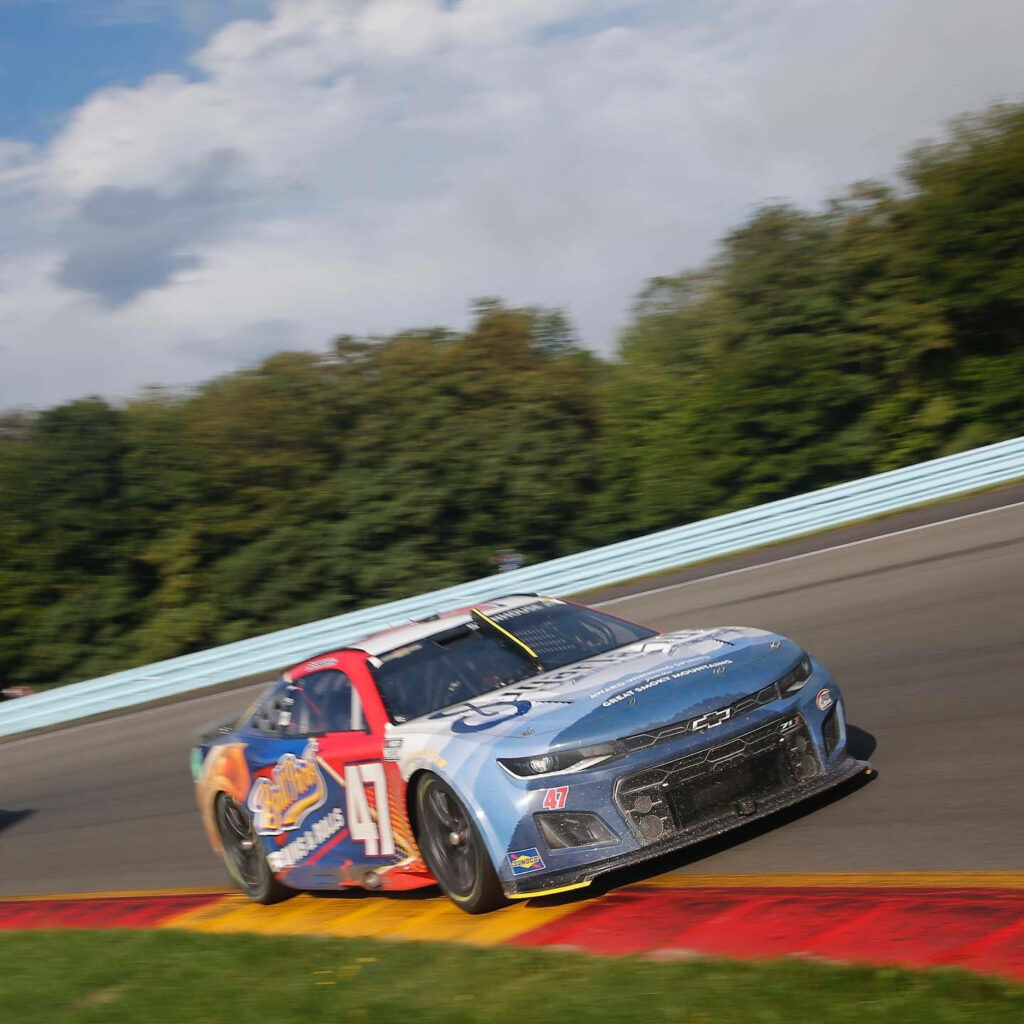 Ricky Stenhouse Jr racing fast in No 47 car on curving track with vibrant motion and energy wallpaper