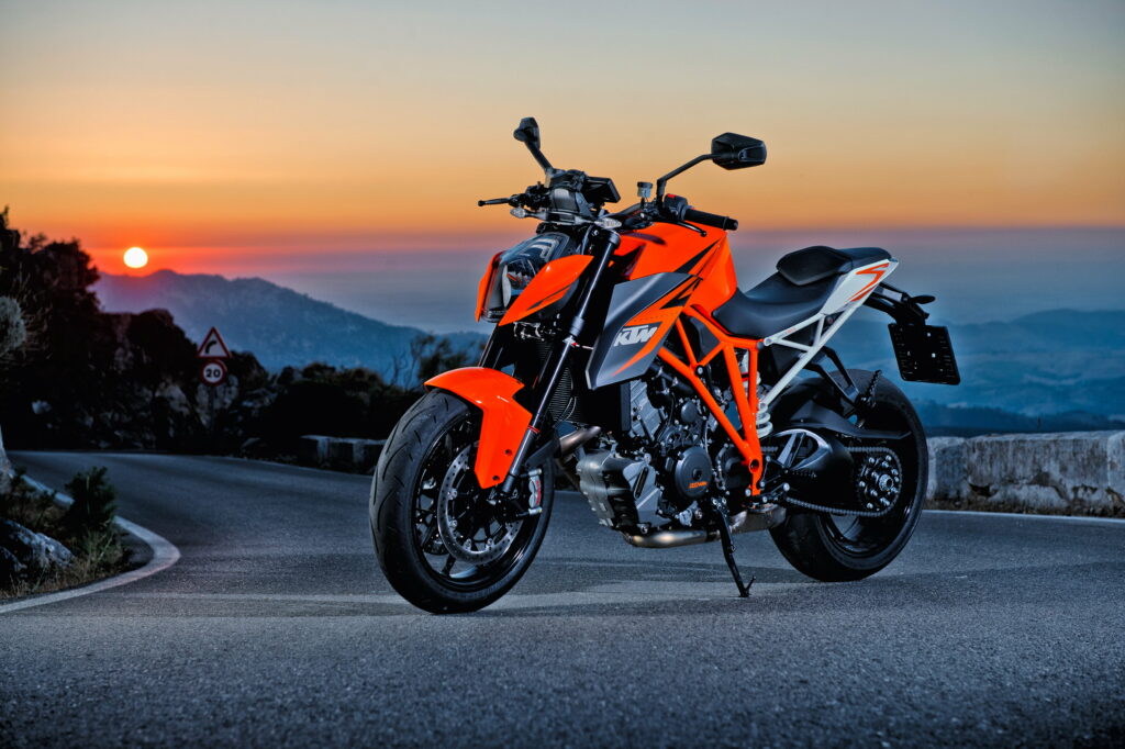 KTM 1290 Super Duke R motorcycle on mountain road at golden sunset showcasing sharp design Wallpaper
