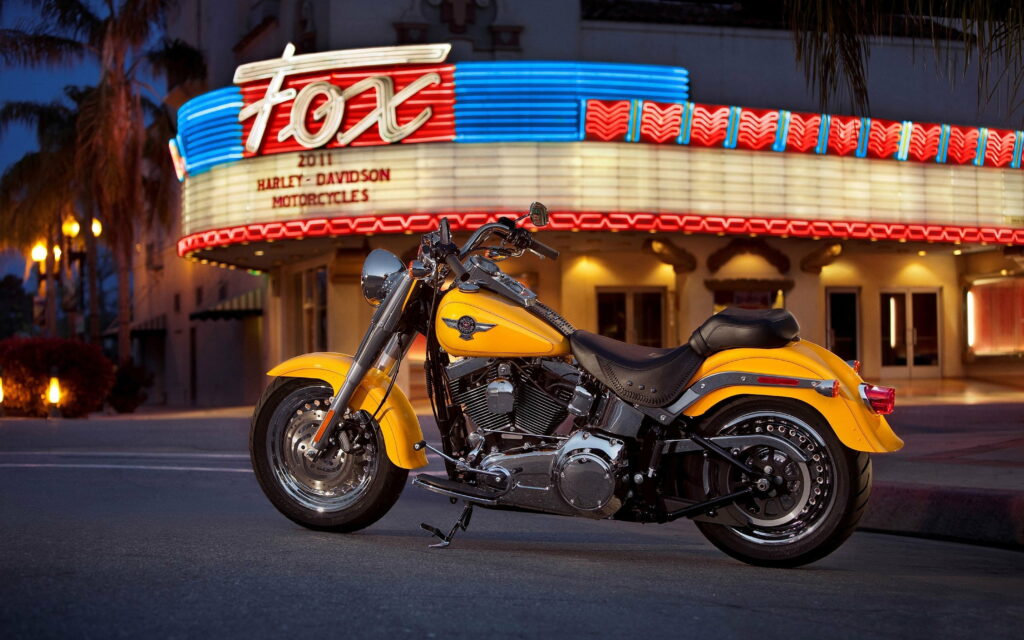 Heroic Harley: A Majestic Fat Boy Roaring Through the Cityscape Wallpaper