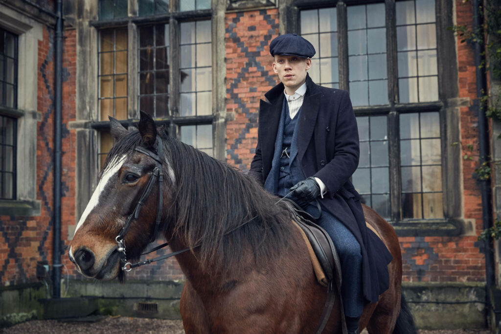The Dapper Horseman: A Captivating 8k Image Showcasing John Shelby in Peaky Blinders' Exquisite Backdrop Wallpaper