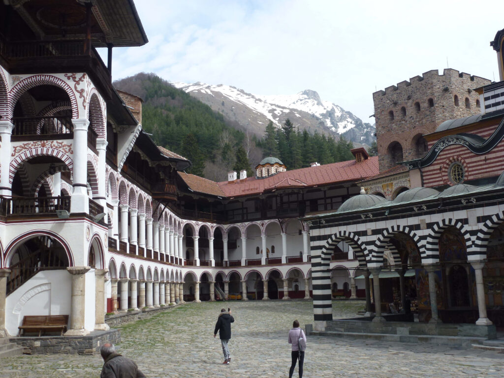 Rila Monastery exterior with striped arches detailed balconies and scenic Bulgarian mountain backdrop wallpaper