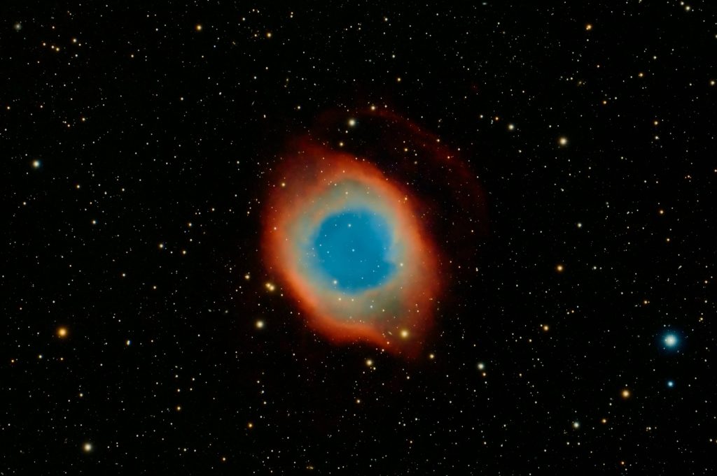 Ring Nebula wallpaper vivid blue core bright reddish orange gas against starry space background