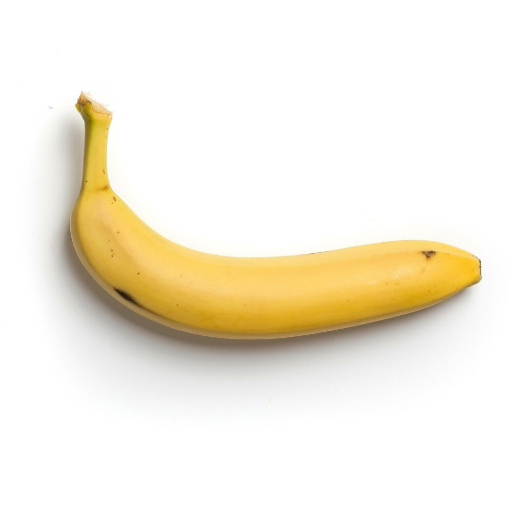 Ripe yellow banana with black spots on white background showing natural texture and color Wallpaper