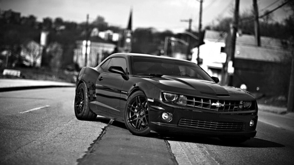 Classic Beast in the Urban Jungle: A Striking Chevrolet Camaro Dominates the Road Wallpaper