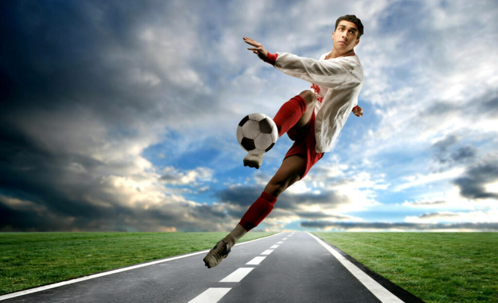 The Dynamic Striker: A Mesmerizing Roadside Mural Depicting A Soccer Genius Amazed in a Kick Pose Wallpaper