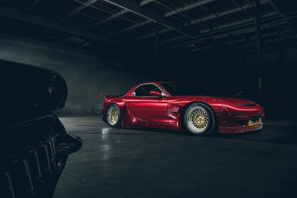 Exquisite Red Mazda RX-7 Showcasing Exquisite Detailing and Golden Rims in an Impressive Automotive Exhibition Wallpaper