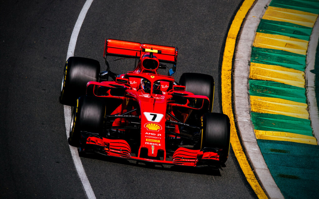 The Thrilling Speed of Ferrari F1 2018 Embracing the Vibrancy of Yellow and Gold Race Track Curbs Wallpaper