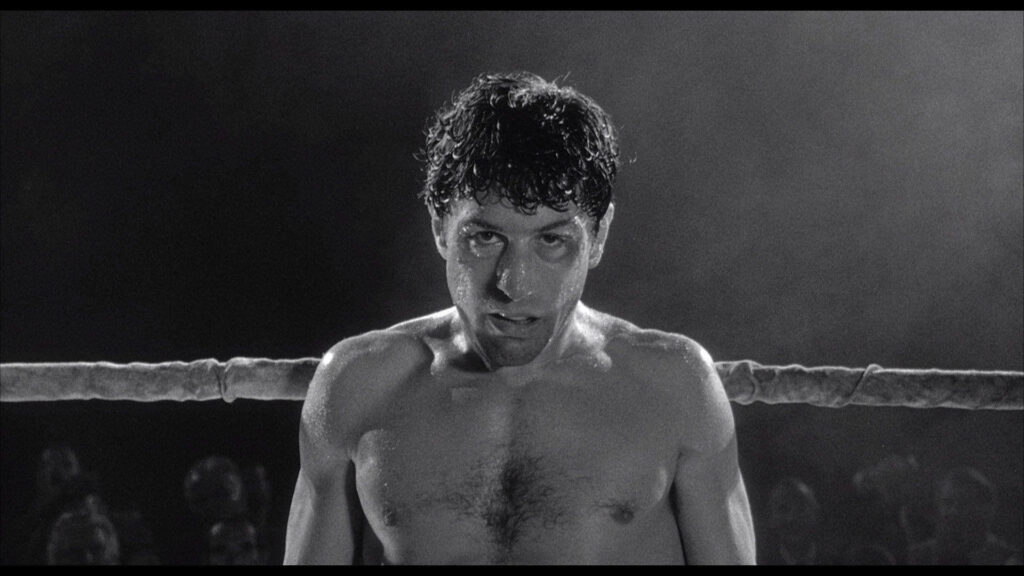 Robert De Niro as Travis Bickle stands intense in boxing ring dramatic Taxi Driver movie scene wallpaper