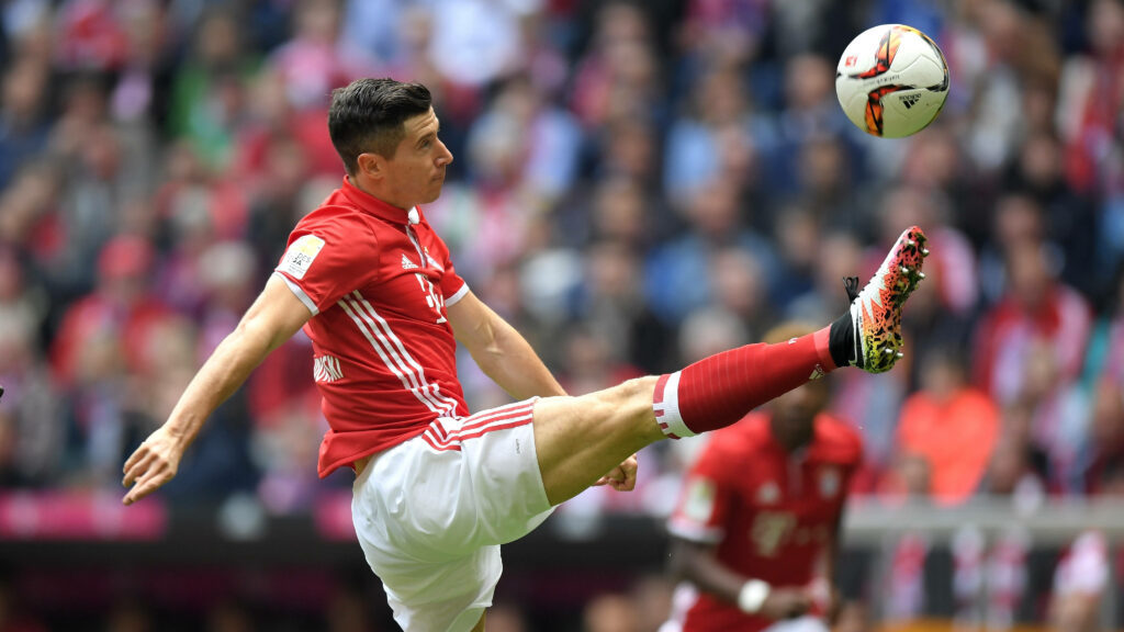 Robert Lewandowski: Precision Striking in Intense Football Match Wallpaper