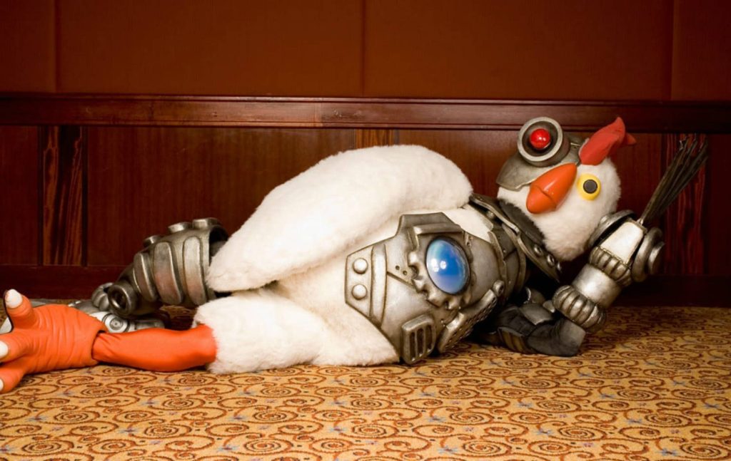 Robot Chicken mascot in metallic armor lounges glowing chest blue light patterned background wallpaper