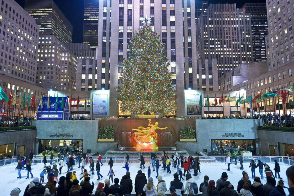 Festive Rockefeller Center: Christmas Tree, Skaters, and Joyful Holiday Scene Wallpaper