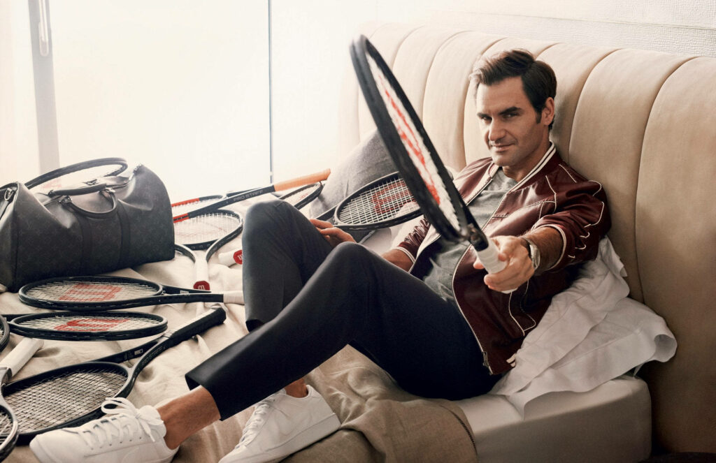 Roger Federer Stylish Wallpaper: Relaxed Pose with Tennis Rackets