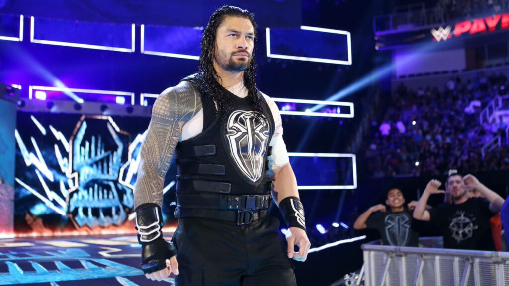 Roman Reigns wrestler entrance with logo gear in vibrant blue arena Wallpaper