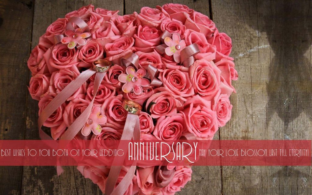 Romantic anniversary wallpaper with heart-shaped pink roses gold rings on rustic wood background