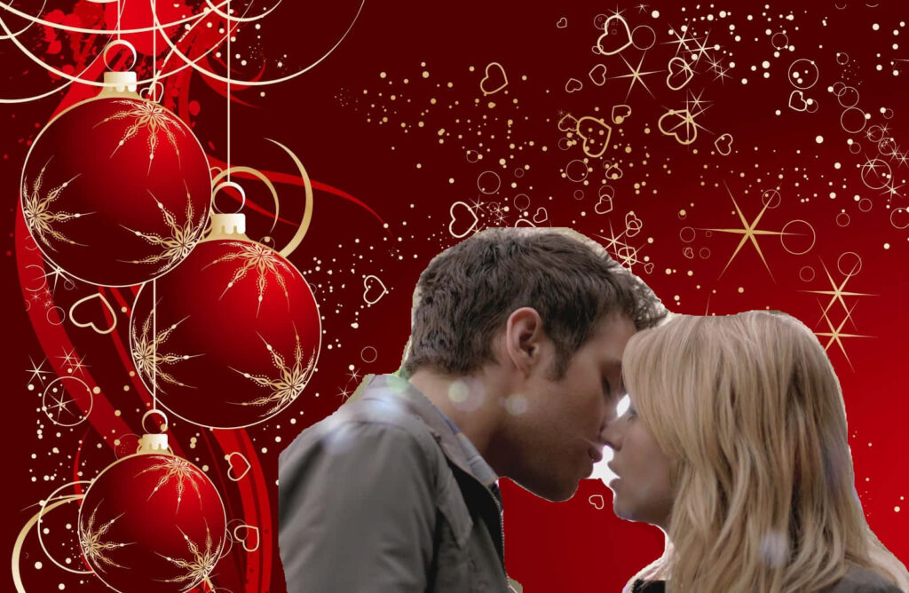 Festive Romantic Wallpaper: Couple Kissing on Red with Christmas Ornaments