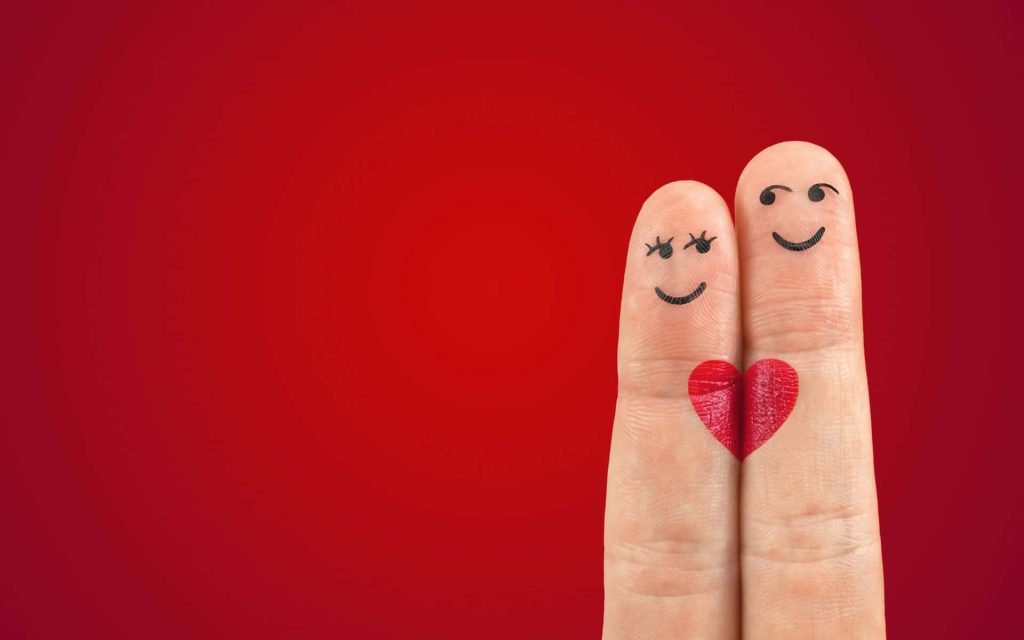 Romantic finger art with smiling faces and red heart on vibrant light red background wallpaper