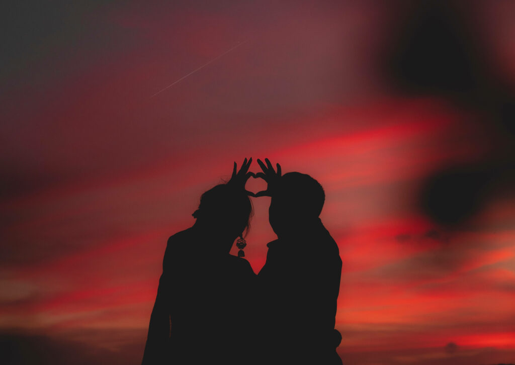 Romantic Finger Heart Silhouette at Fiery Red Sunset Wallpaper