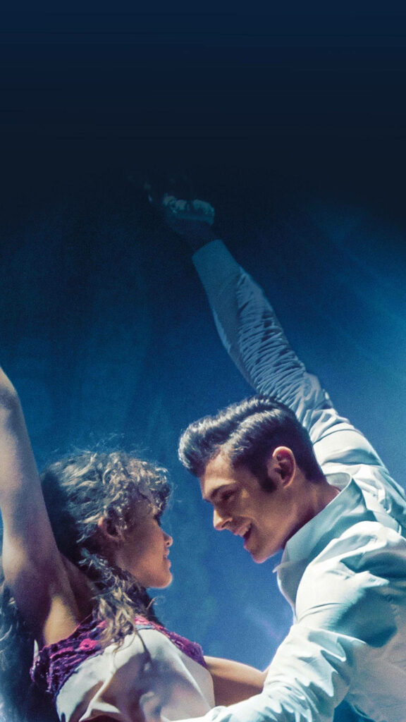 Romantic Greatest Showman wallpaper with passionate lovers in vibrant circus performance scene