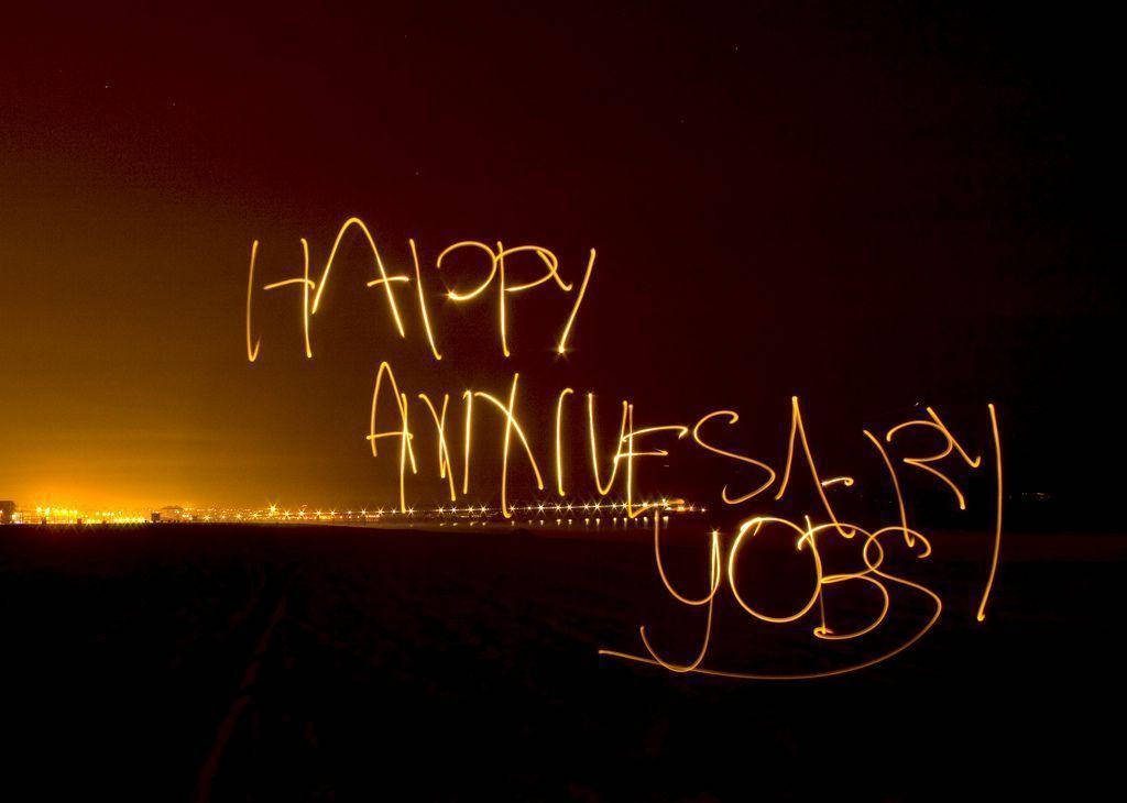 Romantic Happy Anniversary Jobs light painting wallpaper with glowing cursive text and city skyline