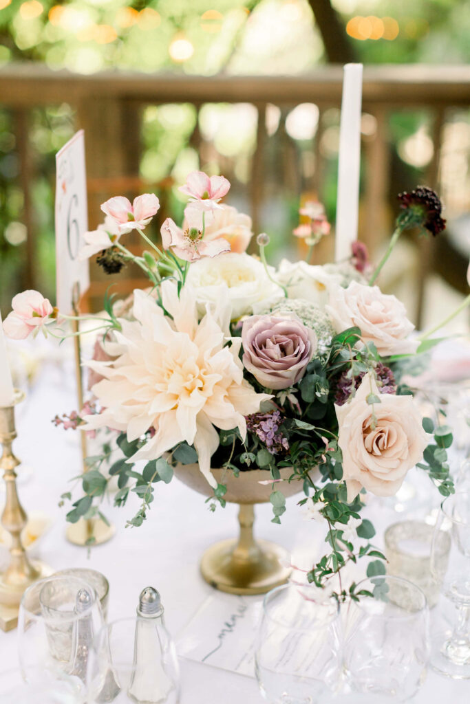 Elegant pastel floral centerpiece with blush roses cream dahlias gold vase and candles wallpaper