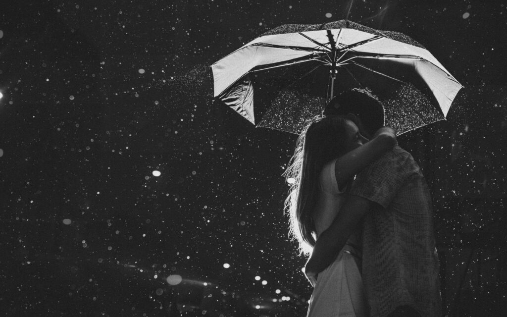 Captivating Monochrome Photograph: Rainy Romantic Moment Under Umbrella for a Deeply Soulful Background Wallpaper