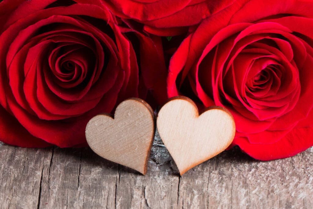 Romantic Red Roses on Rustic Wood: Charming Heart Background Wallpaper