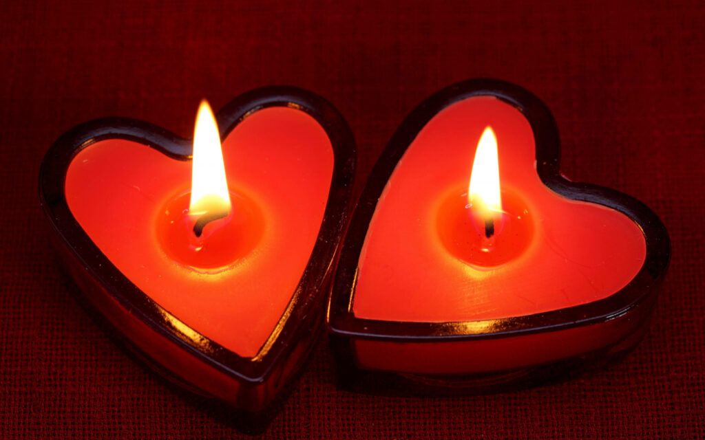 Romantic Wallpaper: Glowing Heart-Shaped Candles on Red Background