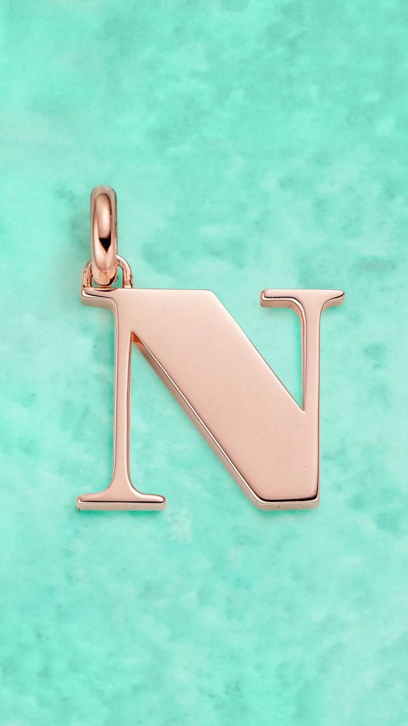 Rose gold pendant letter N on soft mint green textured background elegant wallpaper