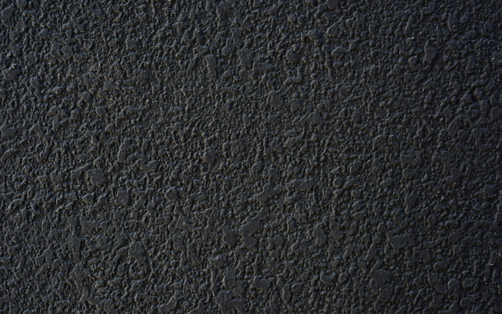 Black stone wall wallpaper with rugged texture and dramatic lighting for dark desktop background