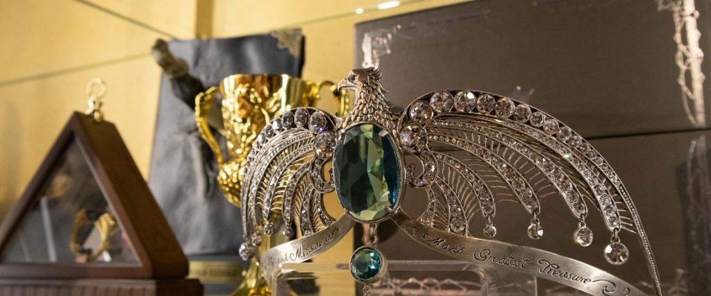 Close-up of Rowena Ravenclaw’s Diadem with eagle design and golden Hufflepuff Cup background wallpaper